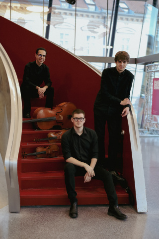 Das Trio ( 3 Männer) auf einer roten geschwungenen Treppe