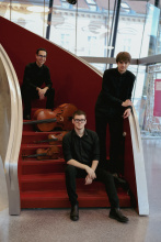 Das Trio ( 3 Männer) auf einer roten geschwungenen Treppe