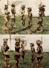 Holzschnitzfiguren weibl.und männl. "PANfiguren"auf grüner Wiese vor erodierender Steinmauer